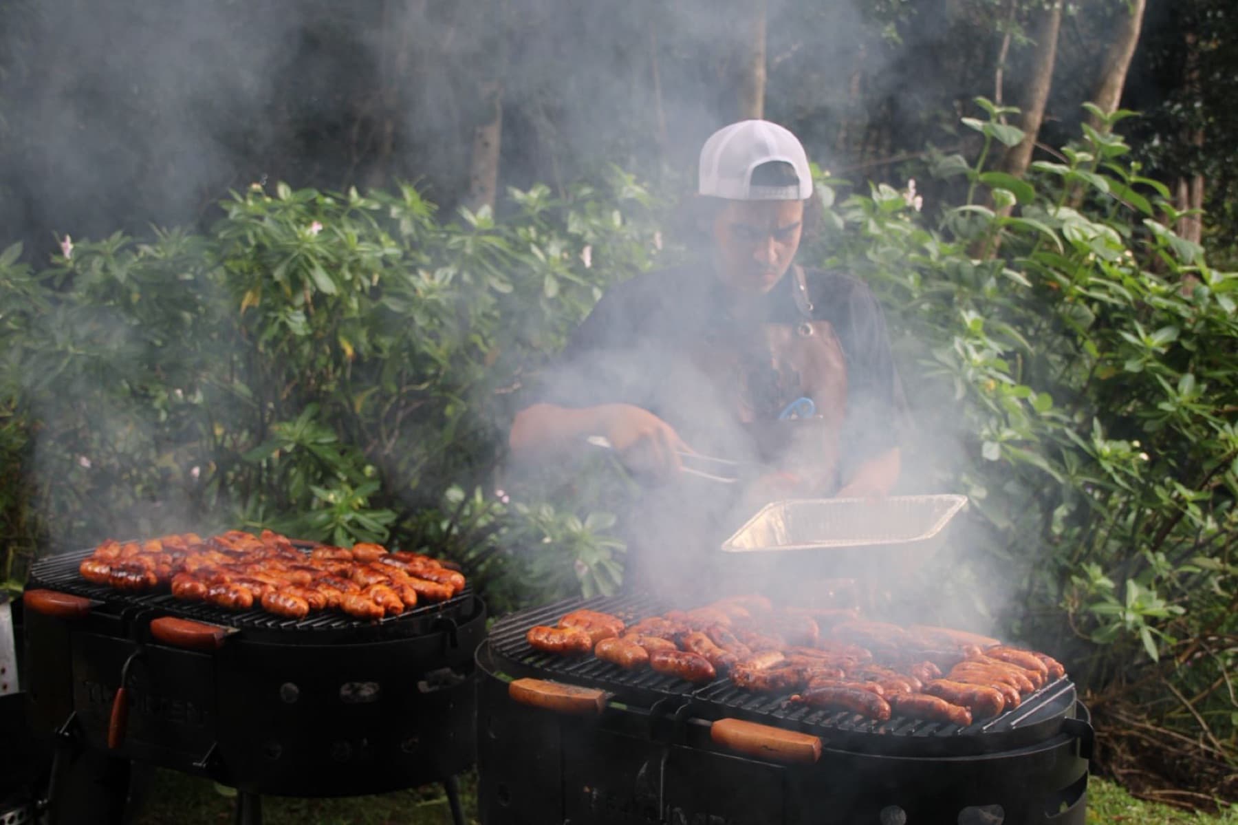 Parrillero cocinando entre el humo